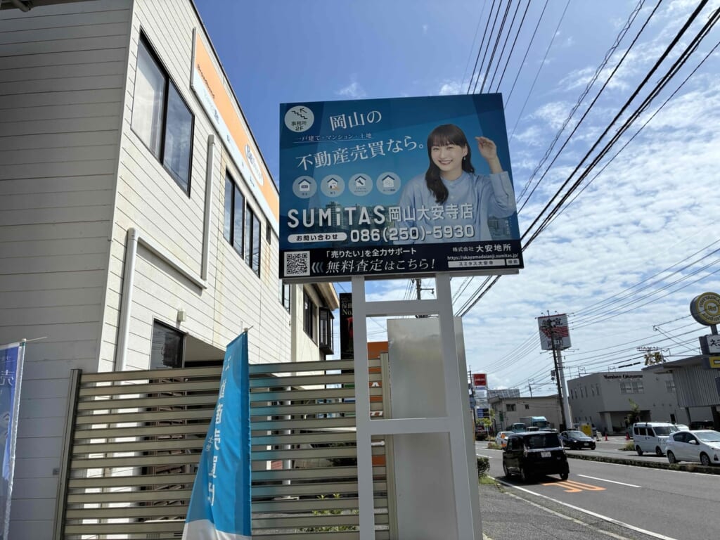 事務所が2階にあることが分かる看板と建物の写真